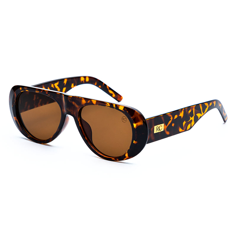 Modelo utilizando o Óculos de sol feminino máscara Rosa Coral Mantova, armação tartaruga e lente marrom – estilo sofisticado e proteção UVA e UVB 400 para os olhos.