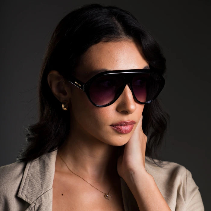 Modelo utilizando óculos de sol feminino Rosa Coral Norma, armação Preta e lente Gradiente – estilo sofisticado e proteção UVA e UVB 400 para os olhos.