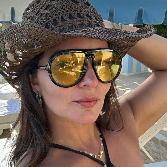Modelo utilizando óculos de sol feminino Rosa Coral Veneto, armação Preta e lente Amarela – estilo sofisticado e proteção UVA e UVB 400 para os olhos.