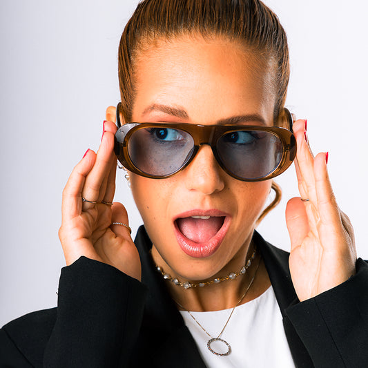 Modelo utilizando o Óculos de sol feminino máscara Rosa Coral Mantova, armação mel e lente azul  – estilo sofisticado e proteção UVA e UVB 400 para os olhos.