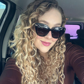 Modelo utilizando Óculos Clip-On feminino Rosa Coral Barcelona, armação Preta e Clip Cinza – estilo sofisticado e proteção UVA e UVB 400 para os olhos.