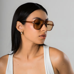 Modelo utilizando óculos de sol feminino Rosa Coral Messina, armação Marrom e lente Marrom – estilo sofisticado e proteção UVA e UVB 400 para os olhos.