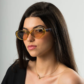 Modelo utilizando óculos de sol feminino Rosa Coral Emilia, armação Leopardo e lente Marrom – estilo sofisticado e proteção UVA e UVB 400 para os olhos.