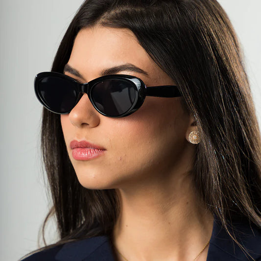 Modelo utilizando óculos de sol feminino Rosa Coral Emilia, armação Preta e lente Preta – estilo sofisticado e proteção UVA e UVB 400 para os olhos.