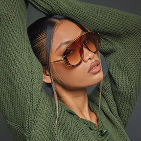 Modelo utilizando óculos de sol feminino Rosa Coral Marsala, armação Leopardo e lente Marrom – estilo sofisticado e proteção UVA e UVB 400 para os olhos.
