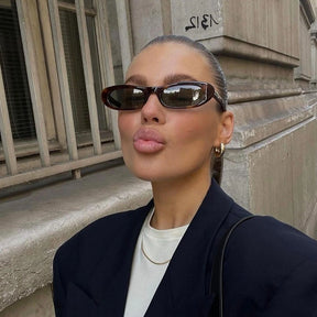 Modelo utilizando óculos de sol feminino Rosa Coral Matera, armação Leopardo  e lente Verde – estilo sofisticado e proteção UVA e UVB 400 para os olhos.