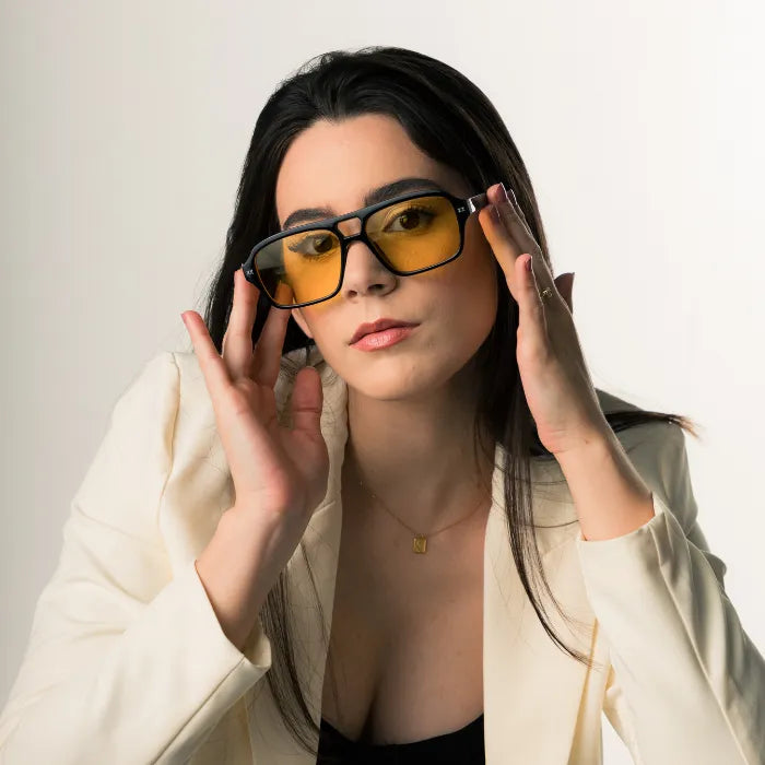 Modelo utilizando óculos de sol feminino Rosa Coral Mira, armação Preta e lente Amarela – estilo sofisticado e proteção UVA e UVB 400 para os olhos.