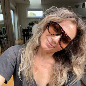 Modelo utilizando óculos de sol feminino Rosa Coral Miranda, armação Leopardo e lente Marrom – estilo sofisticado e proteção UVA e UVB 400 para os olhos.