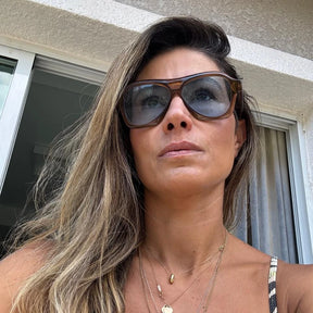 Modelo utilizando óculos de sol feminino Rosa Coral Noasca, armação Marrom e lente Marrom – estilo sofisticado e proteção UVA e UVB 400 para os olhos.