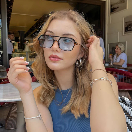 Modelo utilizando óculos de sol feminino Rosa Coral Piemonte, armação Leopardo e lente Azul – estilo sofisticado e proteção UVA e UVB 400 para os olhos.