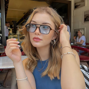 Modelo utilizando óculos de sol feminino Rosa Coral Piemonte, armação Leopardo e lente Azul – estilo sofisticado e proteção UVA e UVB 400 para os olhos.