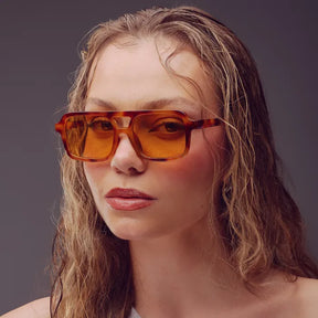 Modelo utilizando óculos de sol feminino Rosa Coral Roma, armação Leopardo com lente Amarela - sofisticado e proteção UVA e UVB 400 para os olhos.