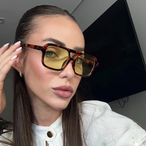 Modelo utilizando óculos de sol feminino Rosa Coral Roma, armação Leopardo e lente Verde - sofisticado e proteção UVA e UVB 400 para os olhos.