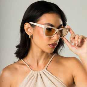 Modelo utilizando óculos de sol feminino Rosa Coral Verona, armação bege e lente Marrom – estilo sofisticado e proteção UVA e UVB 400 para os olhos.