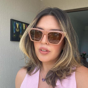 Modelo utilizando óculos de sol feminino Rosa Coral Verona, armação Marrom e lente Marrom– estilo sofisticado e proteção UVA e UVB 400 para os olhos.