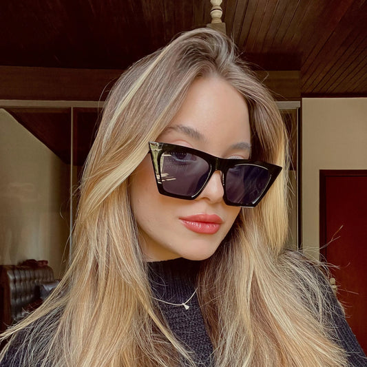 Modelo utilizando óculos de sol feminino Rosa Coral Verona, armação Preta e lente Preta – estilo sofisticado e proteção UVA e UVB 400 para os olhos.