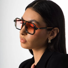 Modelo utilizando óculos de sol feminino aviador Rosa Coral Villanova, armação Cinza e lente Rosa – estilo sofisticado e proteção UVA e UVB 400 para os olhos.