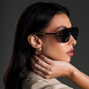 Modelo utilizando óculos de sol feminino aviador Rosa Coral Villanova, armação Preta e lente Cinza – estilo sofisticado e proteção UVA e UVB 400 para os olhos.