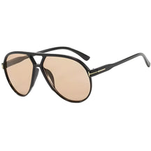 Modelo utilizando óculos de sol feminino Rosa Coral Marche, armação Preta e lente Marrom – estilo sofisticado e proteção UVA e UVB 400 para os olhos.